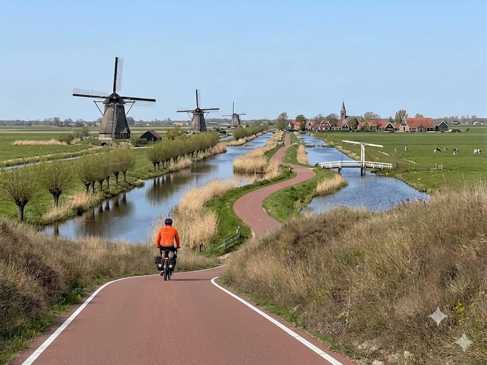 Three Pino tandems with pilots and riders in orange jerseys, lined up ready to ride.